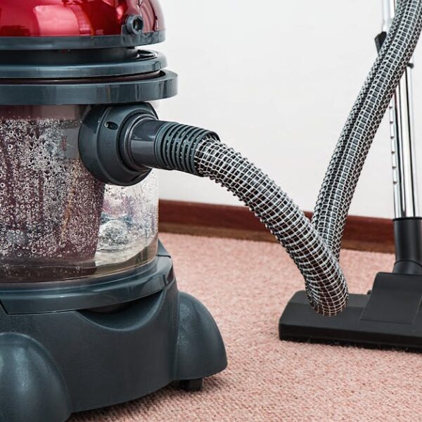 Close-up of a modern vacuum cleaner with water filtration on carpet floor indoors
