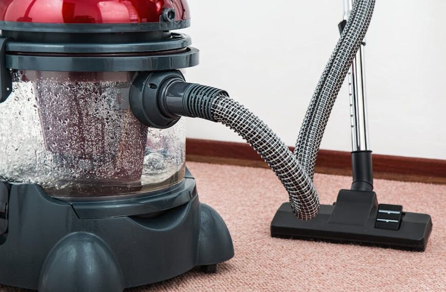 Close-up of a modern vacuum cleaner with water filtration on carpet floor indoors
