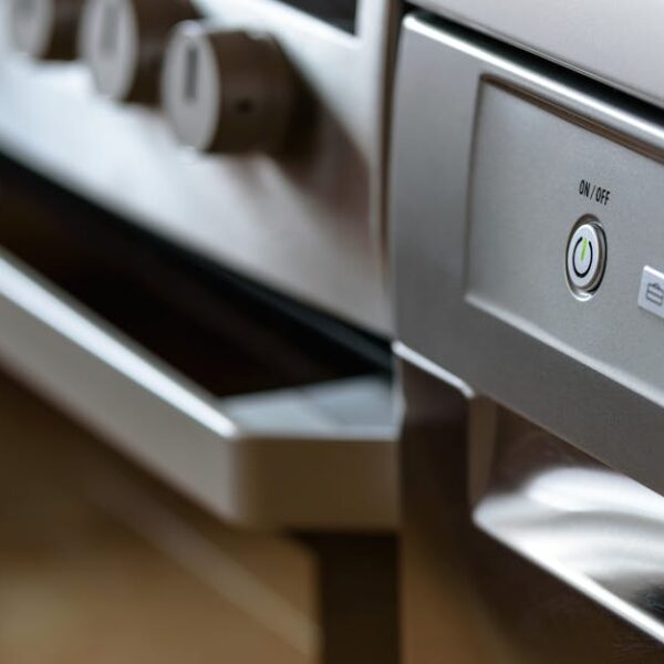 Close-up view of modern stainless steel kitchen appliances with focus on dishwasher and oven
