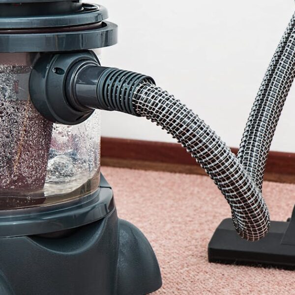 Close-up of a modern vacuum cleaner with water filtration on carpet floor indoors