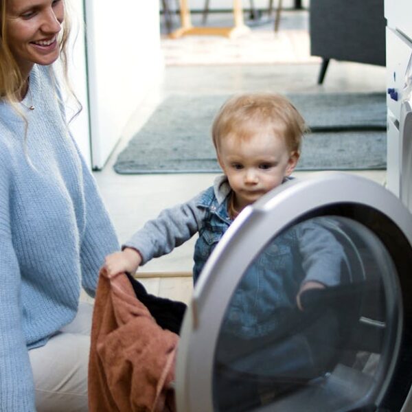 Mother and toddler joyfully doing laundry together, fostering family bonding at home