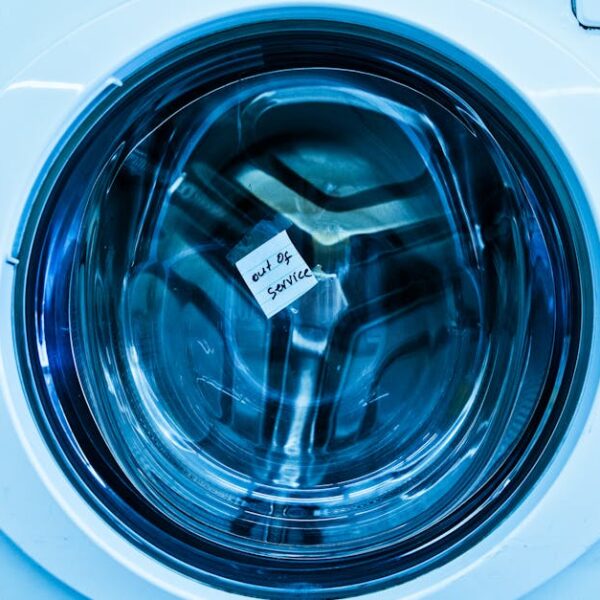 Close-up of an out-of-service washing machine in a laundromat with a blue tint