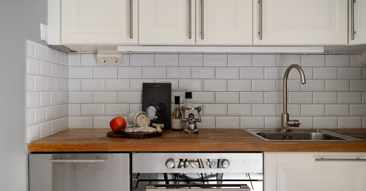 Stylish modern kitchen interior with white cabinets and wooden countertop, featuring kitchen essentials