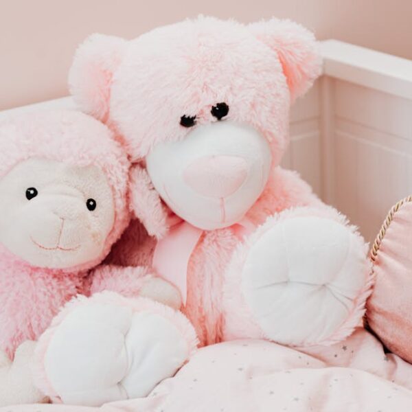 Cute pink plush toys on a bed in a childrens room, exuding comfort and innocence
